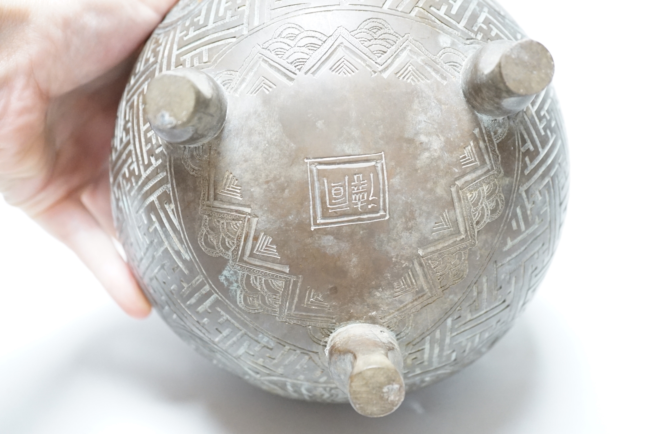 A Chinese three footed cast and chased bronze globular censer and cover, c.1900, 20cm high